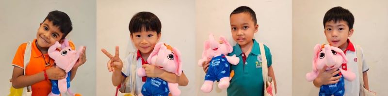 Image of four multi-racial boys smiling while holding an elephant soft toy